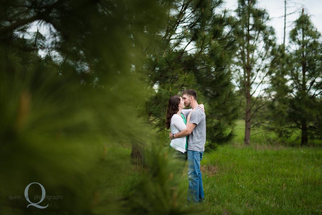 engagement kissing photo by trees