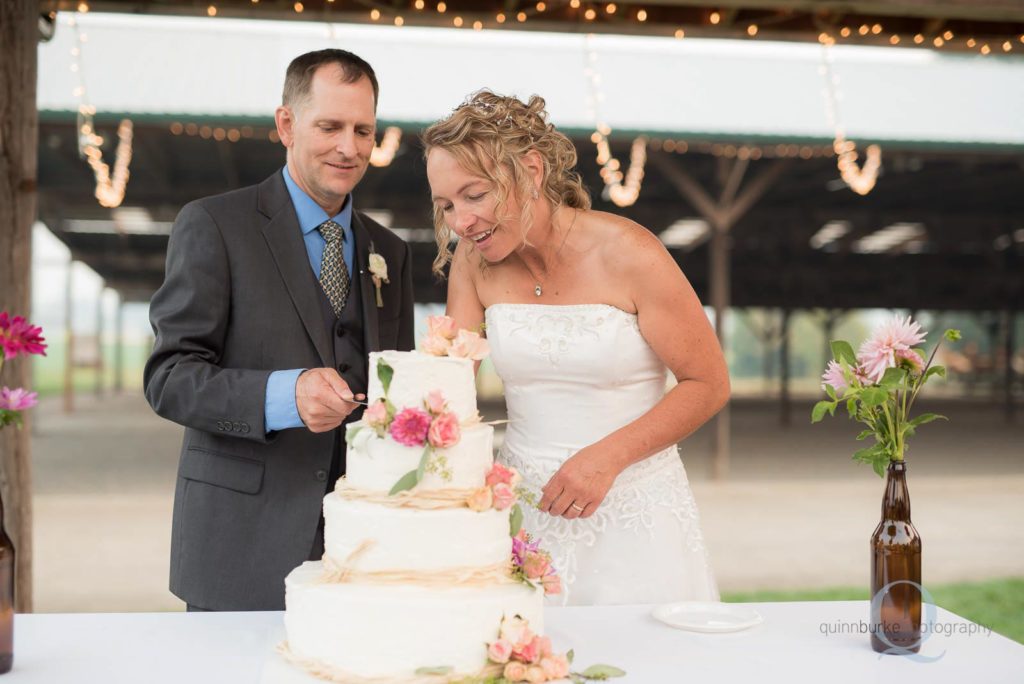 bride and groom cut wedding cake