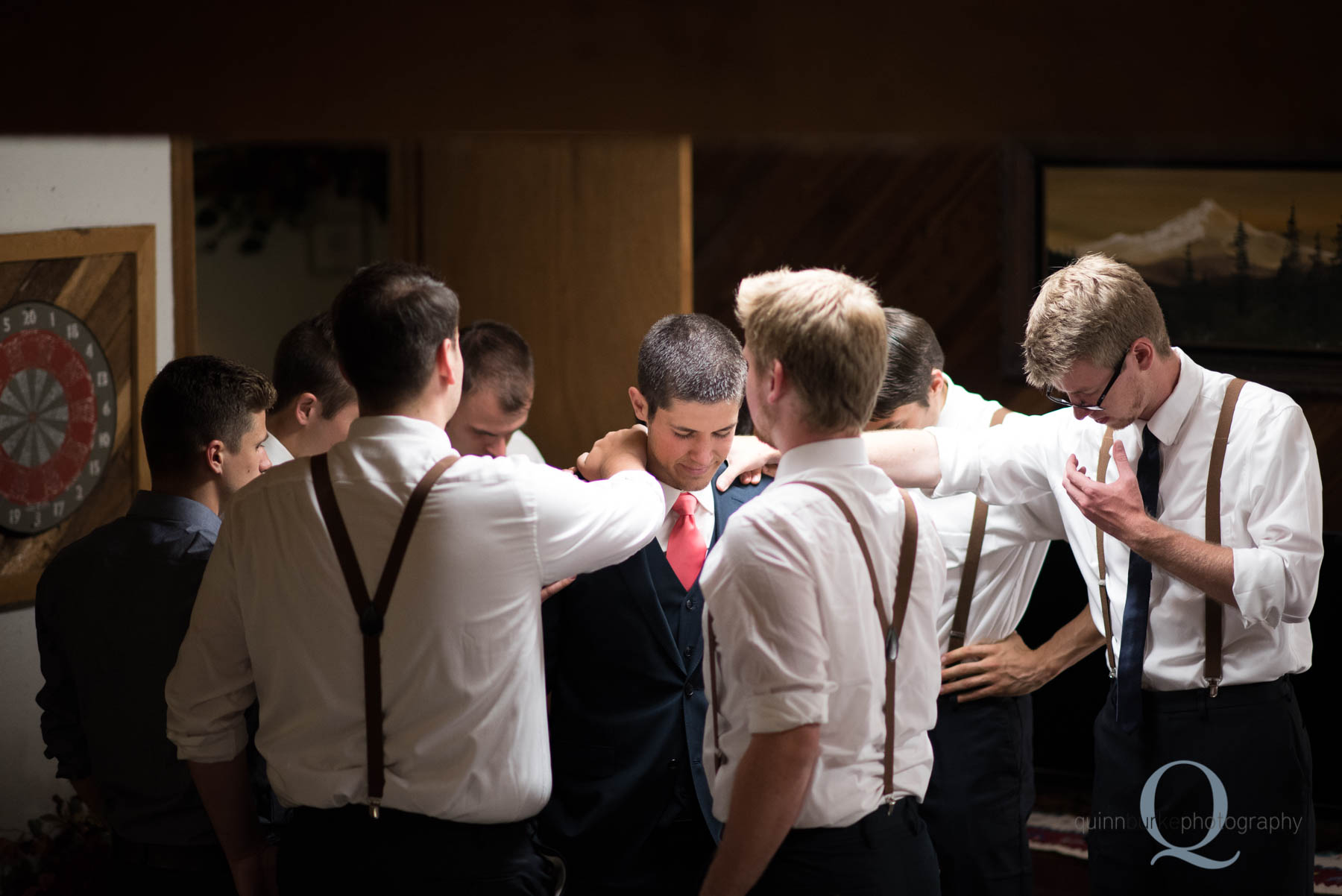 groomsmen praying for groom before wedding