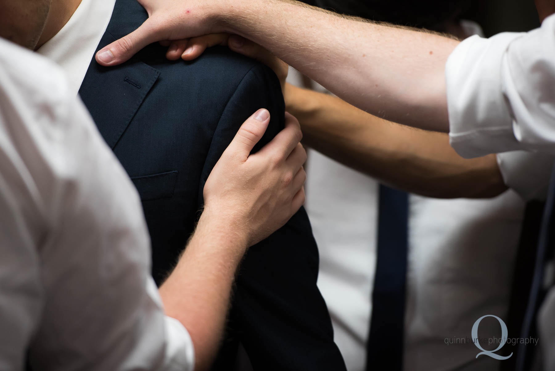 laying hands on groom before wedding