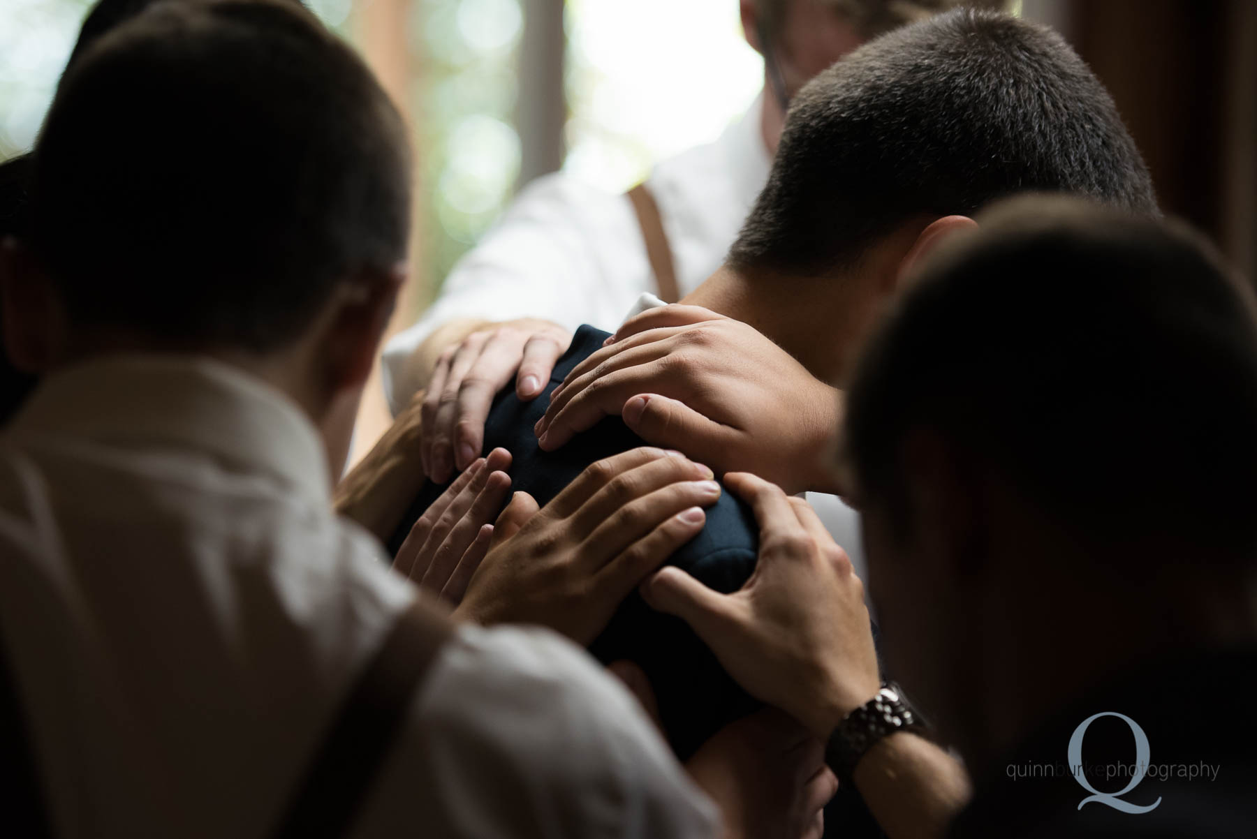 laying hands on groom in prayer