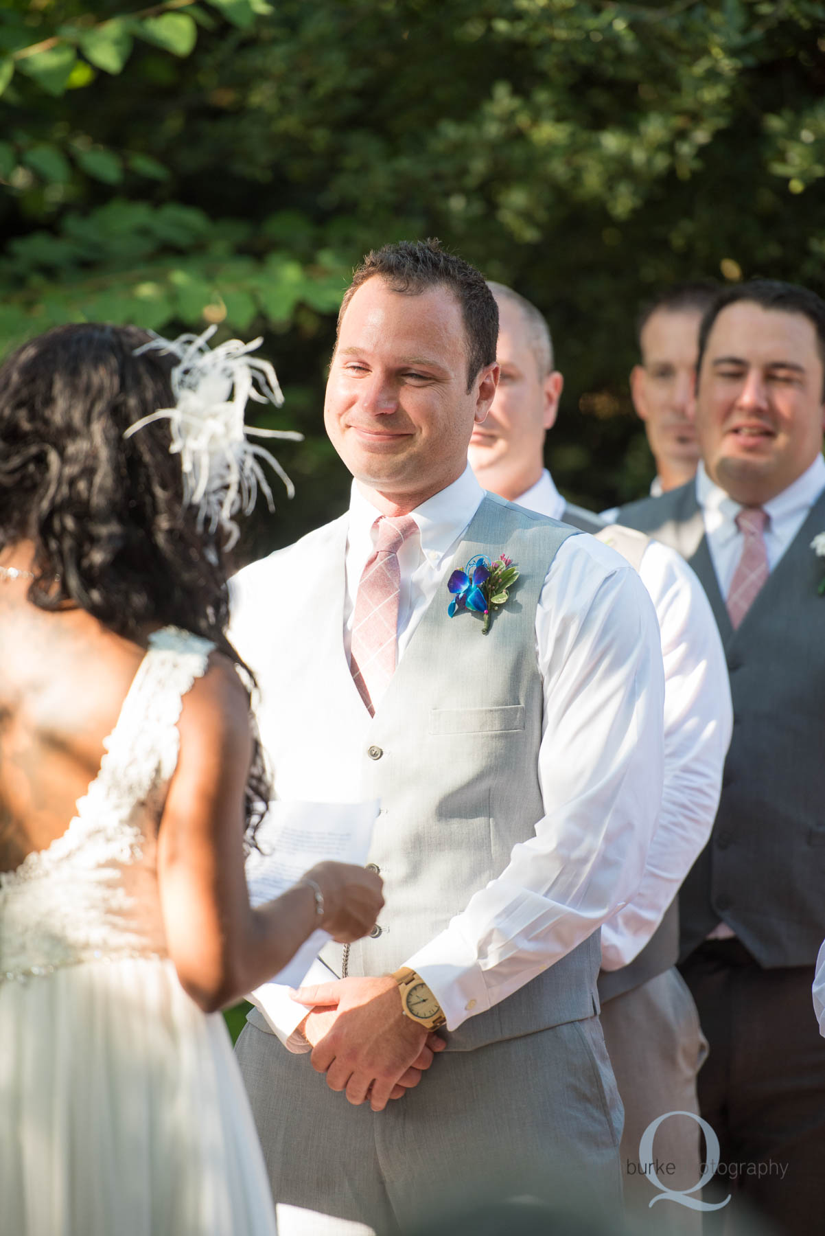 groom smiling at bride during wedding ceremony