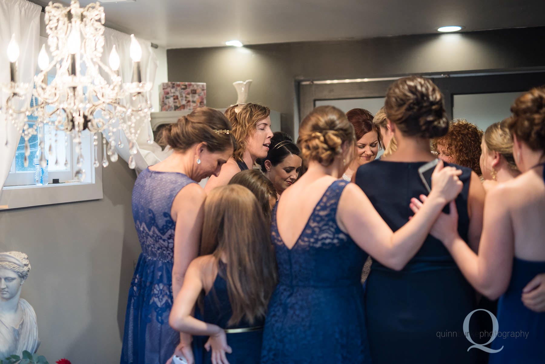 bridesmaids praying for bride before wedding