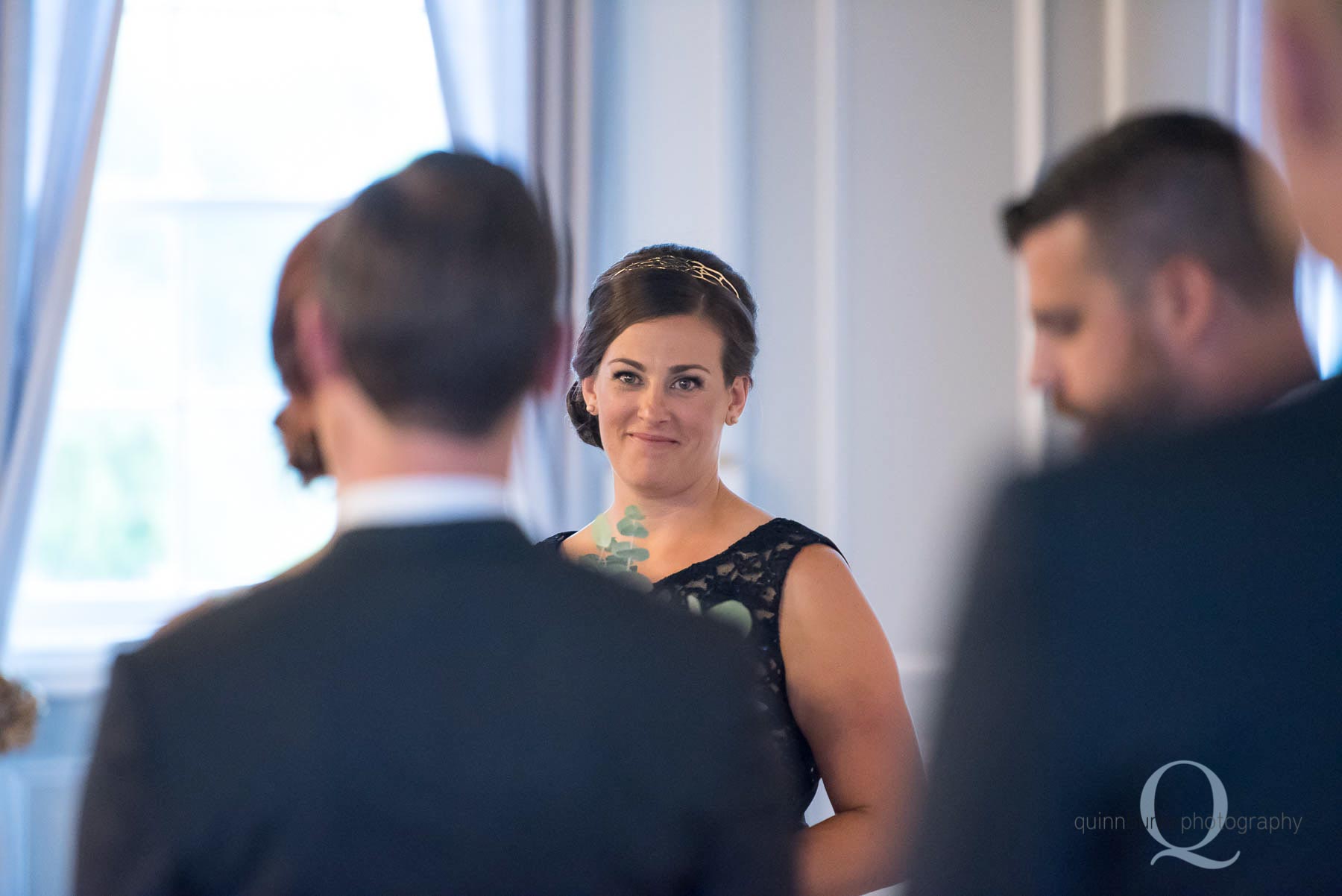 bridesmaids smiling at bride during ceremony