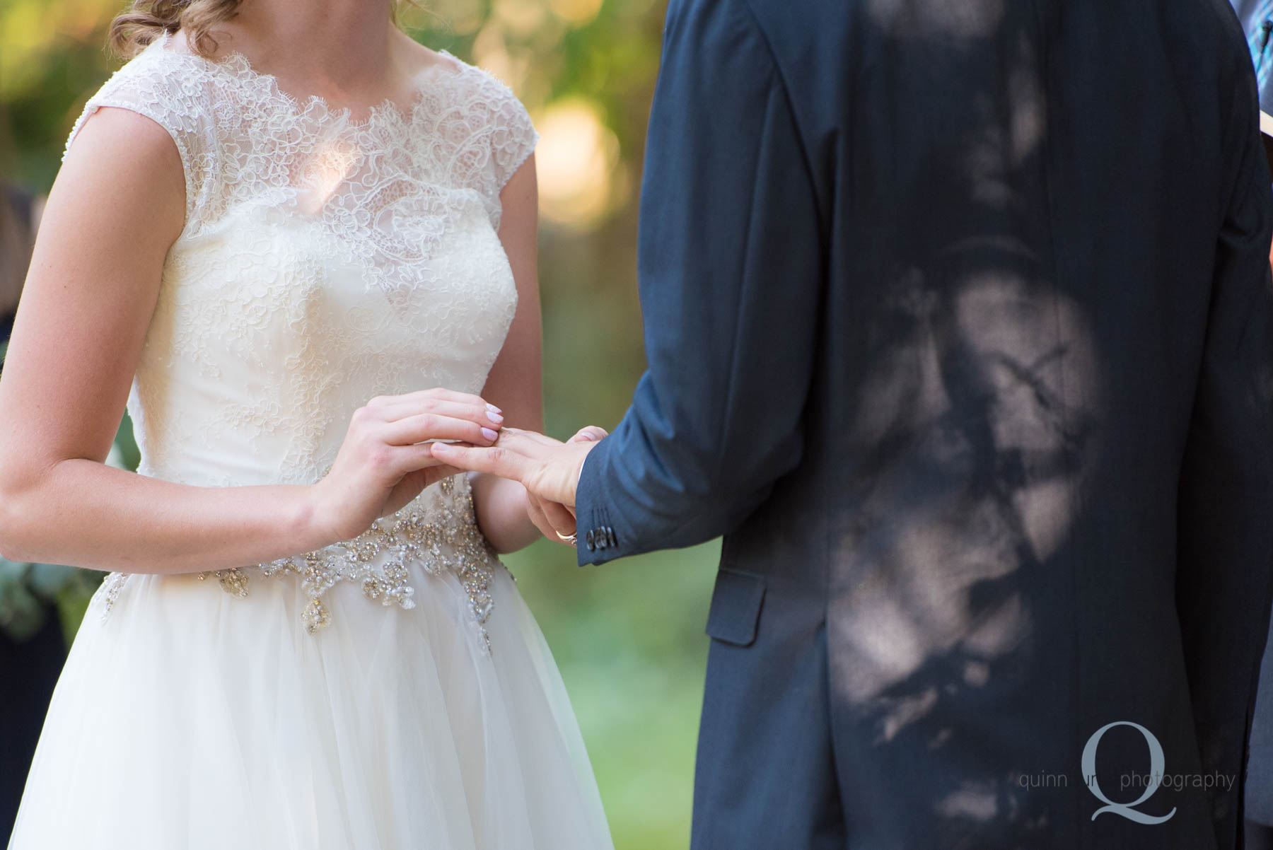 bride putting ring on grooms finger at rons pond