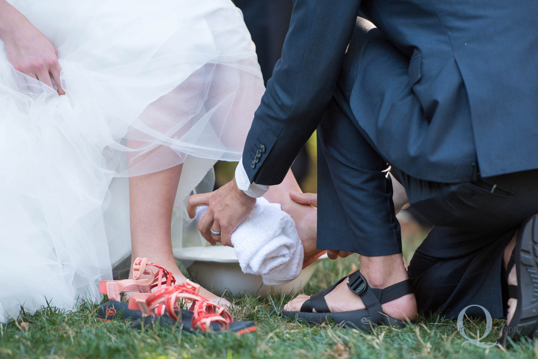 groom washing brides feet during wedding ceremony