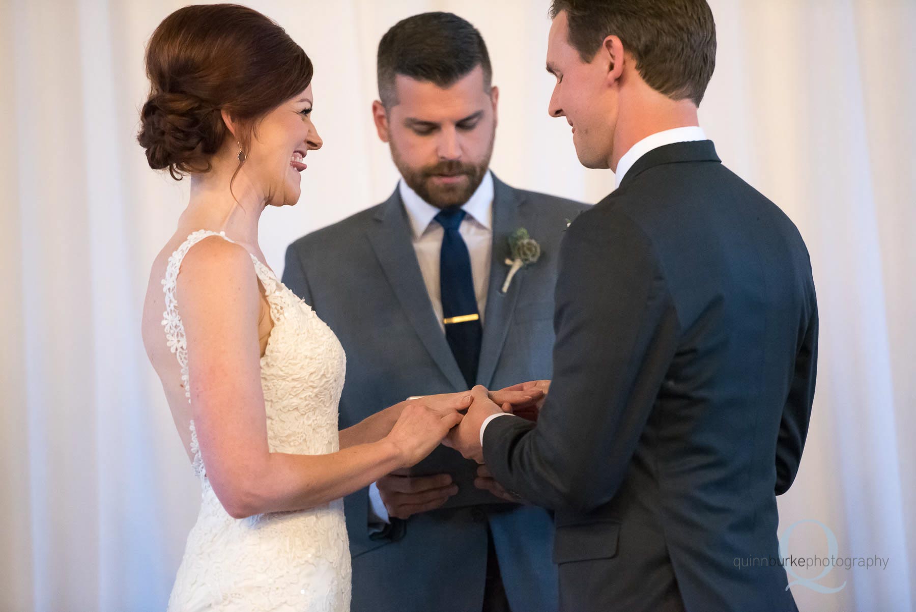 groom placing ring on brides finger during wedding ceremony