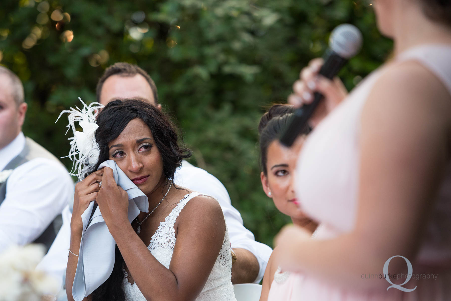 bride wiping away tear during wedding toast