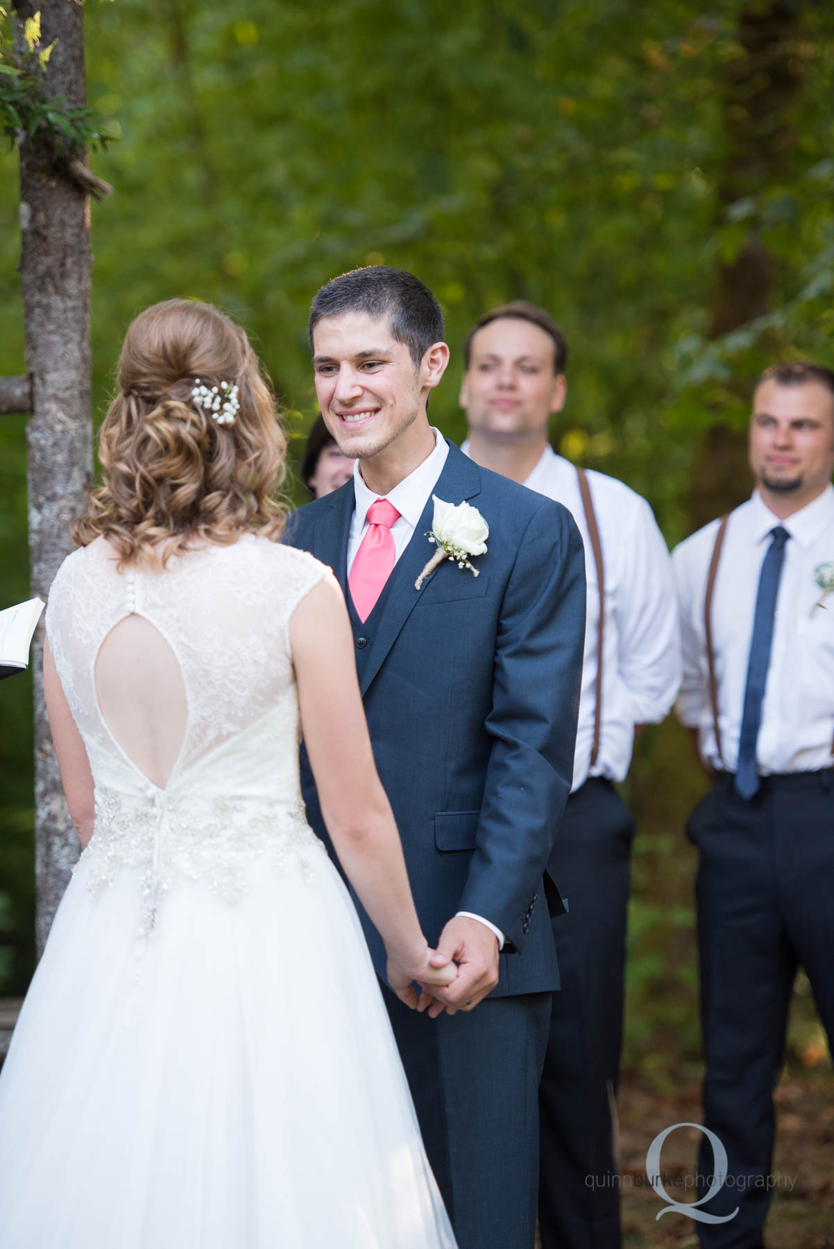 groom smiling at bride during wedding ceremony