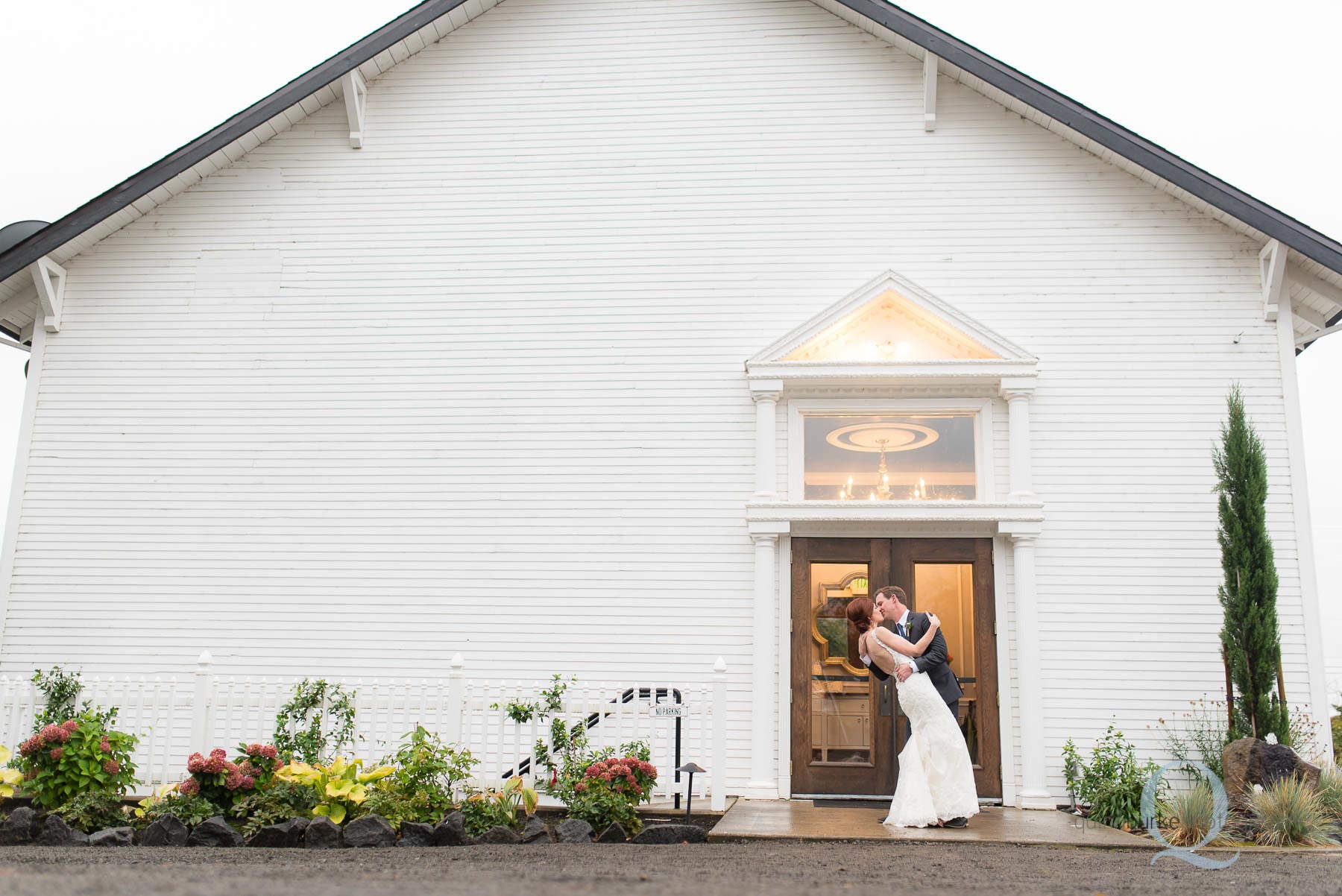 bride and groom kiss outside Old Schoolhouse Newberg