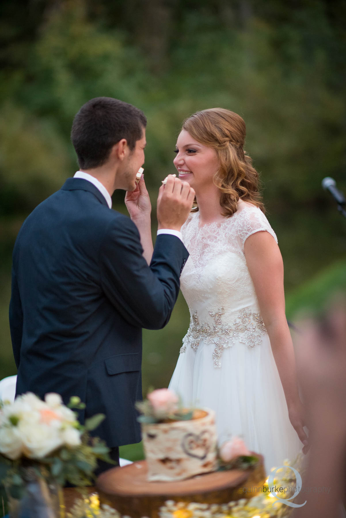 bride and groom feed cake during reception