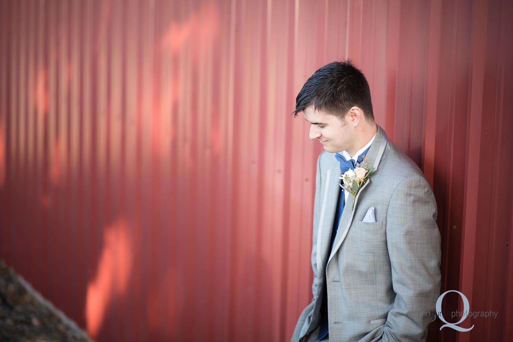 groom against barn before wedding at Perryhill Farm