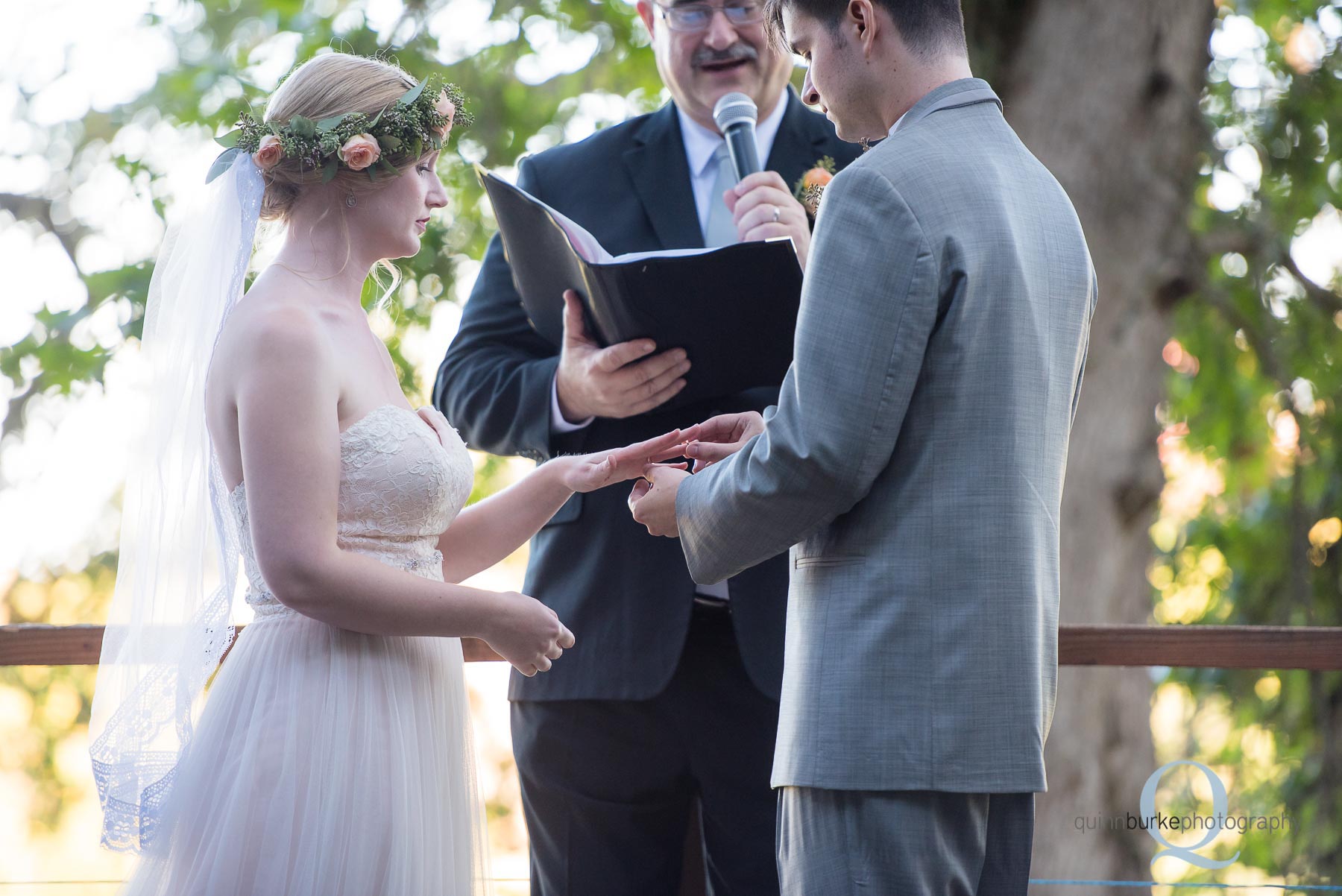 groom places ring on brides finger Perryhill Farm wedding