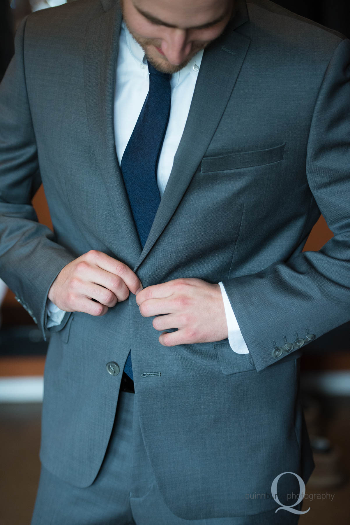 groom buttoning jacket for Green Villa Barn wedding