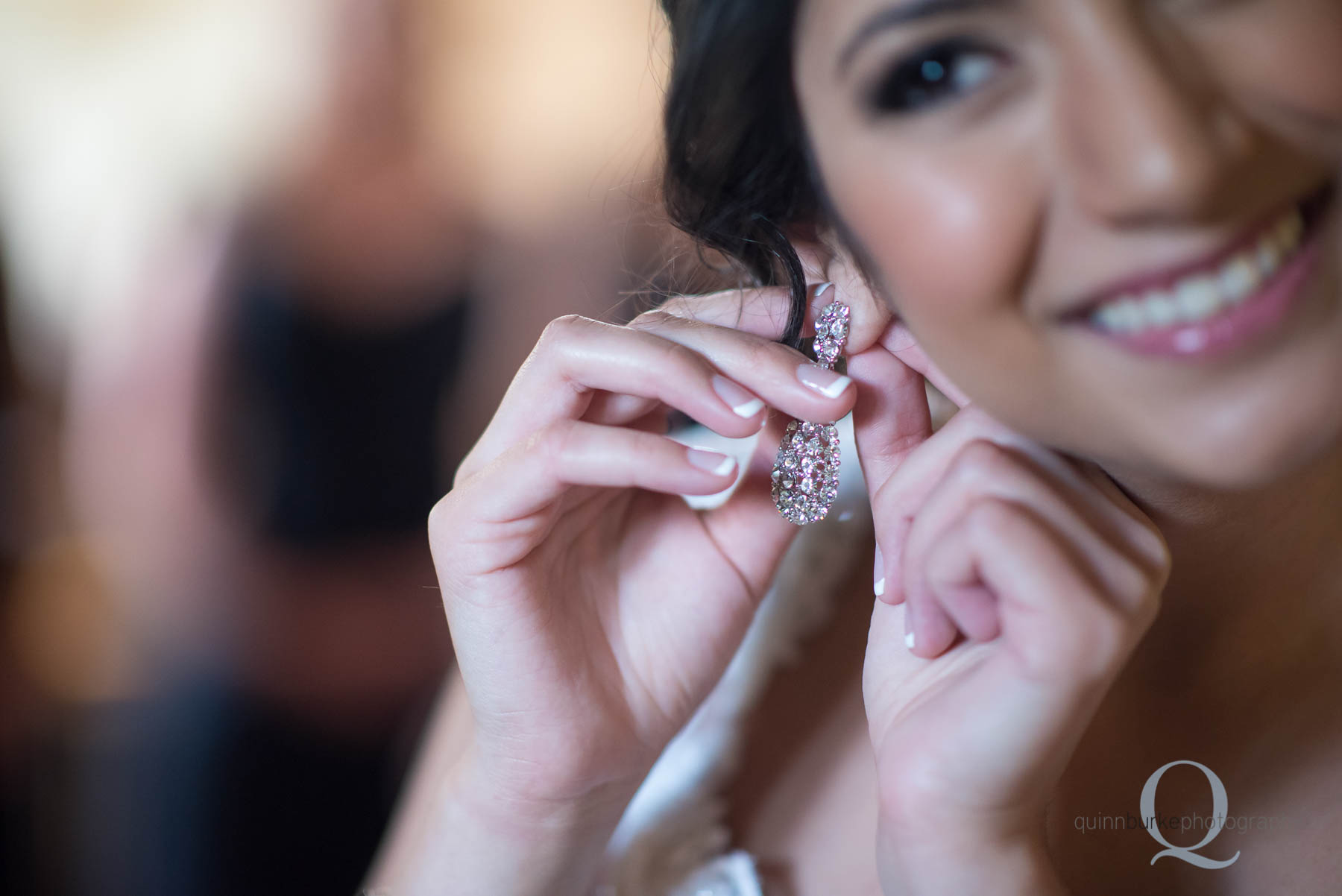 bride putting on earrings at Green Villa Barn