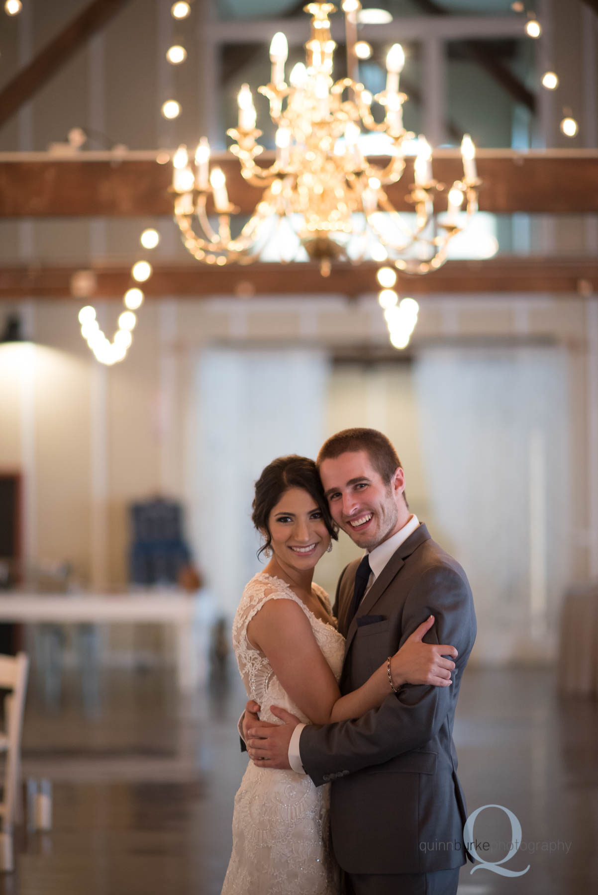 bride and groom under chandelier at Green Villa Barn