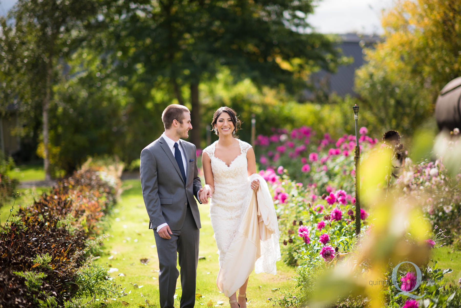 bride and groom walking in flower garden at Green Villa Barn