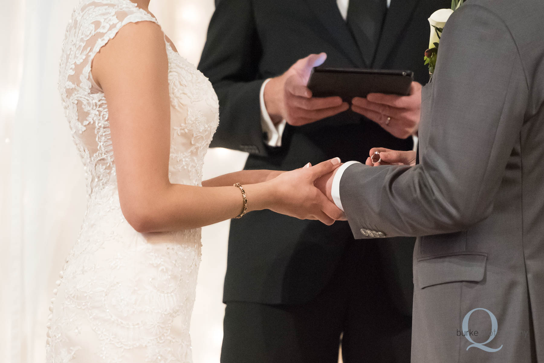 groom placing ring on brides finger Green Villa Barn