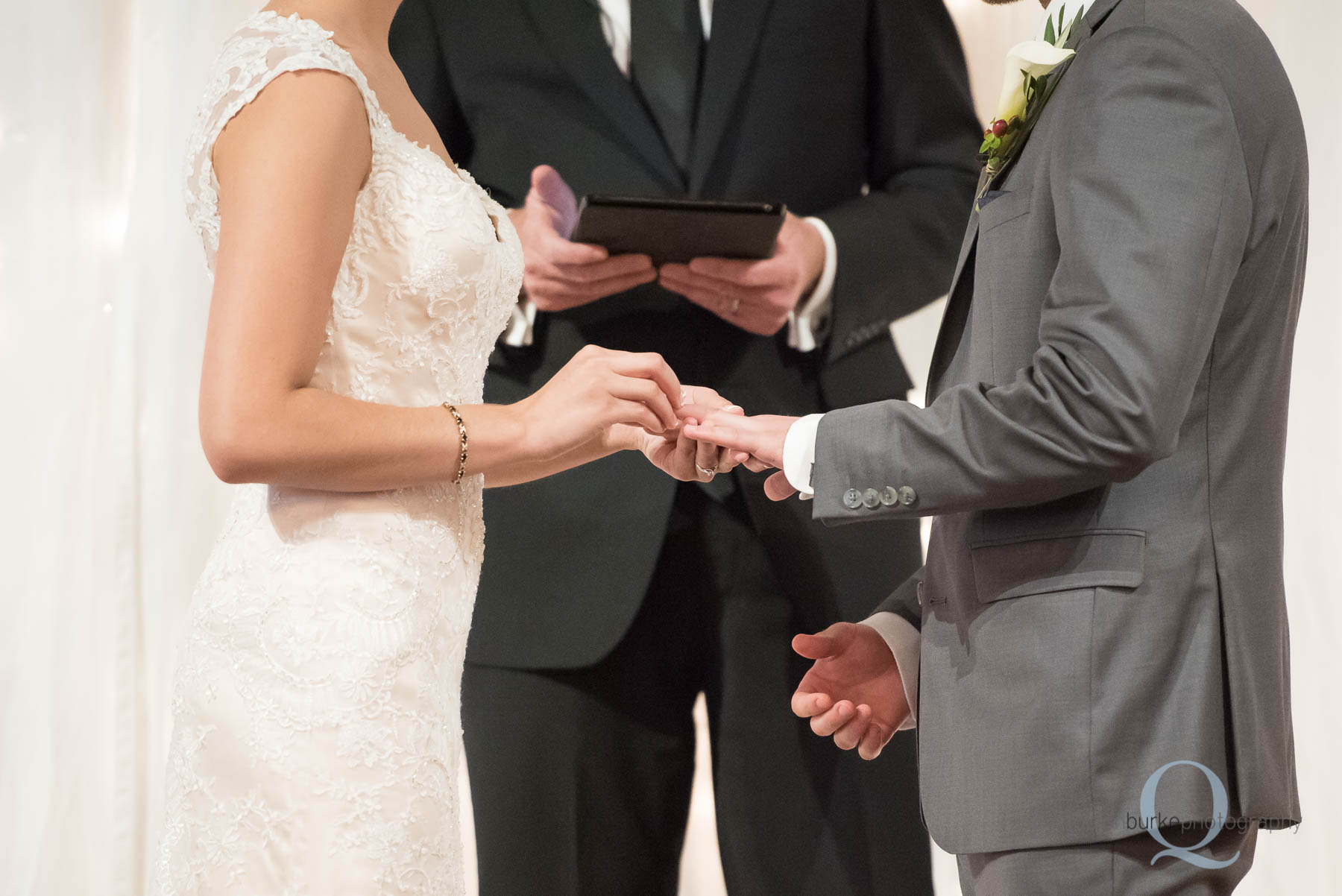 bride placing ring on grooms finger wedding ceremony Green Villa Barn